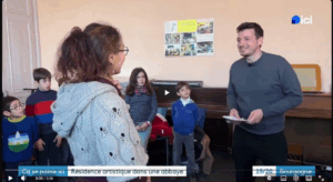 capture d'écran du reportage. On voit les enfants durant leur cour de musique, la directrice de l'école et le journaliste